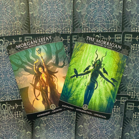 tarot kortos – dvi atverstos kortos žaliu ir gelsvu tonu, rodydamos Morgan Lefay ir The Morrigan dizainus, šiek tiek persidengiančios