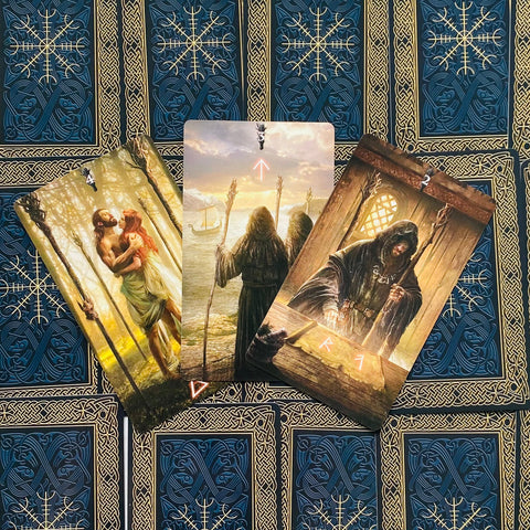 Tarot kortos trijų kortų išklotinė su tamsiai mėlynais aukso ornamentu dėklais ir detaliais mitologiniais iliustracijomis