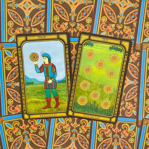 Tarot kortos su pentaklių figūromis — artimas kampas, dvi išklotos kortos ant ornamentuoto nugarėlių fono