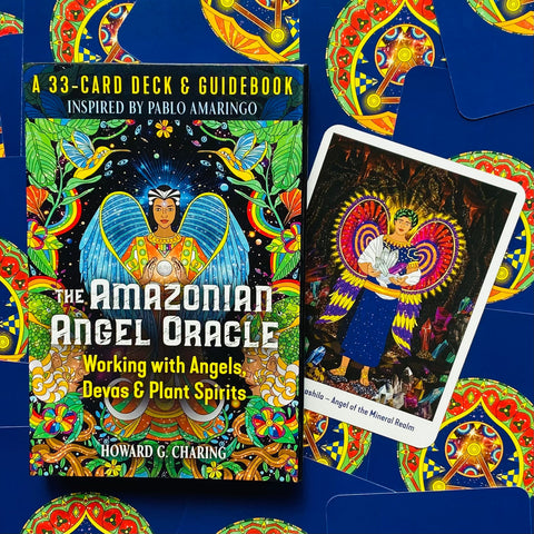 Orakulų kortos Amazonian Angel Oracle, spalvota dėžutė ant mėlyno fono su viena atversta korta dešinėje
