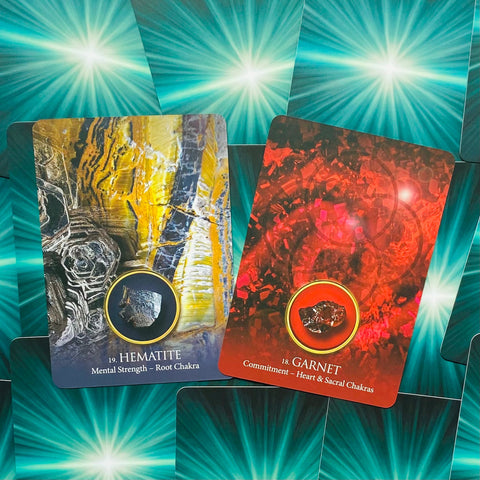 Oracle kortos, atverčiami priekio variantai: Hematite (geltonai‑juoda, šaknų čakrai) ir Garnet (raudona, širdies/sakrala).