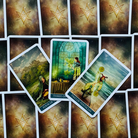 tarot kortos — dviejų, trijų ir keturių pentaklių kortos ant tamsios žvaigždžių nugarėlės, rodomos išdėstytos sklaidoje