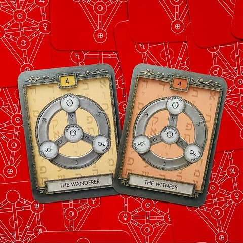 Tarot kortos, dvi kortos The Wanderer (kreminė) ir The Witness (persikinė) su metaliniais žiedais ant raudono simbolinio fono
