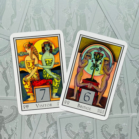 tarot kortos spalvotos priekinės kortos Visitor 7 ir Bridge 6 padėtos kampu ant pilko ornamentuoto fono, artimas planas