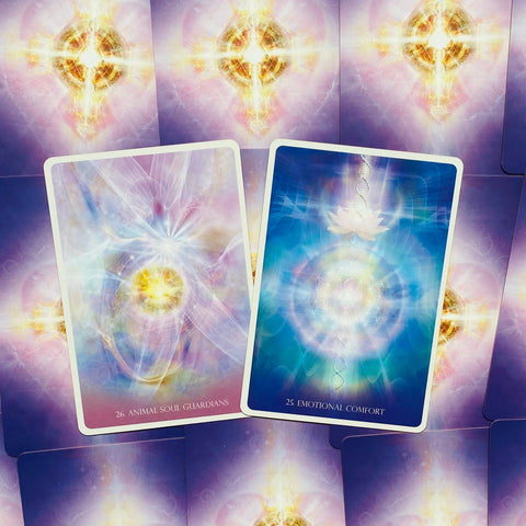 Orakulų kortos pastelinės violetinės ir mėlynos spalvos, dvi kortos pasvirusiu kampu (25 Emotional Comfort, 26 Animal Soul Guardians) skirtos intuityviam skaitymui