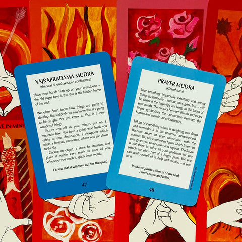 Meditacinės kortos su mėlynu rėmeliu, atverstos kortos Nr.47 Vajrpradama Mudra ir Nr.48 Prayer Mudra ant raudono iliustruoto fono