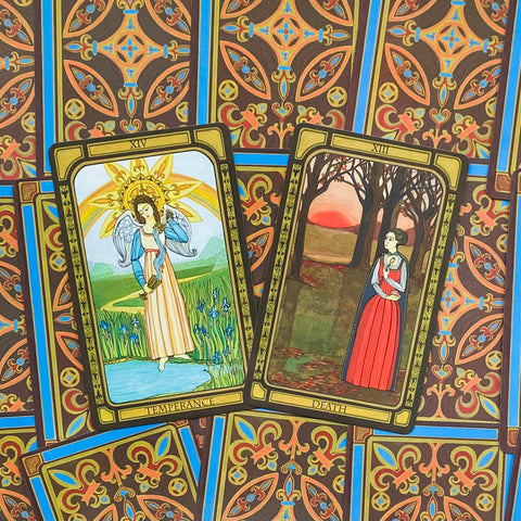 Tarot kortos su dviem Major Arcana kortomis (Temperance ir Death), spalvotos iliustracijos priekyje, ant ryškios raštuotos nugarėlės