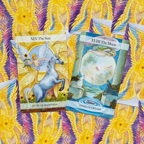 tarot kortos su XIX The Sun ir XVIII The Moon kortomis ant geltonai‑violetinio ornamentuoto fono, iliustracijos aiškiai matomos