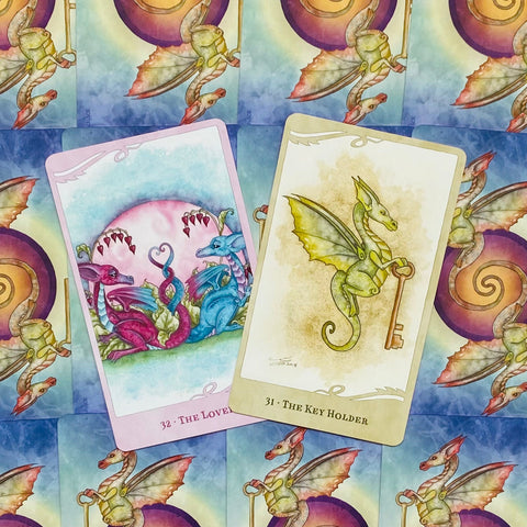 tarot kortos drakonų tematikos, pastelinės rožinės, žalios ir mėlynos, dvi atverstos kortos The Lovers ir The Key Holder ant raštuotos nugarėlės
