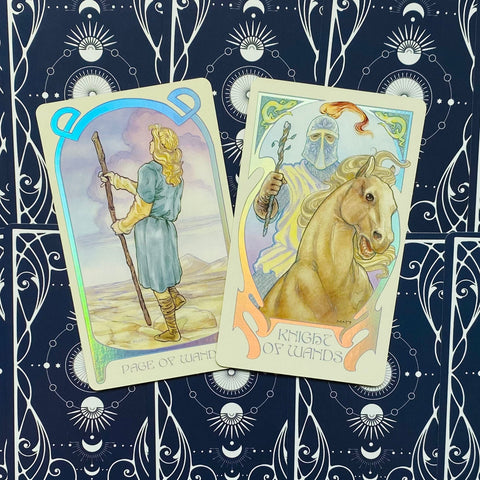 Tarot kortos, dvi kortos (Page of Wands ir Knight of Wands) su holografinėmis kraštinėmis ant tamsiai mėlyno raštuoto fono