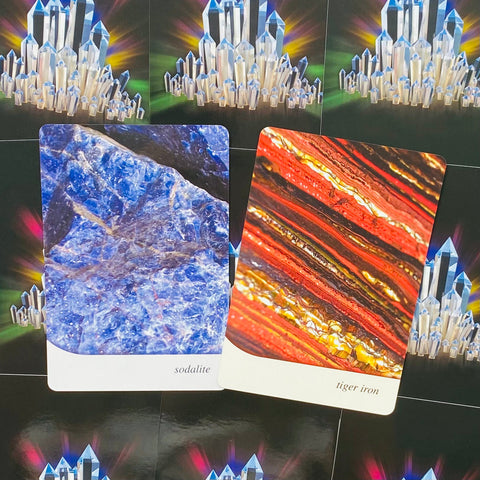 Akmens kortelės sodalite (mėlyna) ir tiger iron (raudona), dvi variantų kortelės, pasvirusios ant juodo kristalų fono