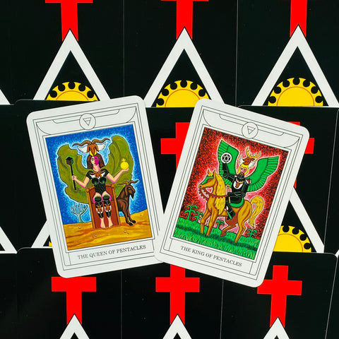 tarot kortos su Queen ir King of Pentacles vaizdais, ryškūs priekiniai kadrai pasvirusios ant juodo nugarėlių su raudonu kryžiumi ir geltonu saulės motyvu