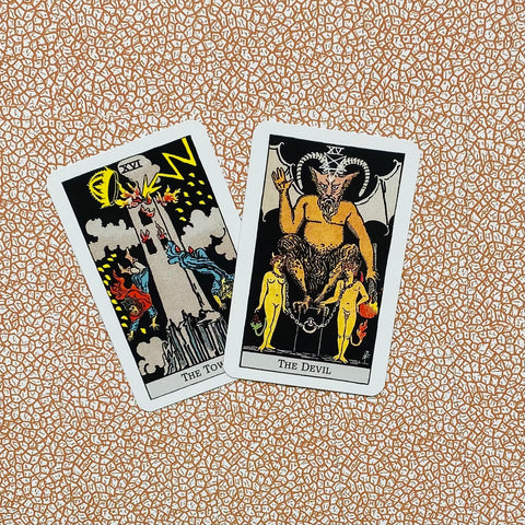 tarot kortos Rider‑Waite stiliaus, dvi didžiųjų arkų kortos The Tower ir The Devil ant raštuoto fono, nuo viršaus matomas kampinis vaizdas