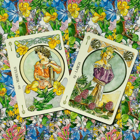Tarot kortos su dviem atvirais meniniais dizainais — geltoniais ir violetiniais motyvais ant spalvingo gėlių fono