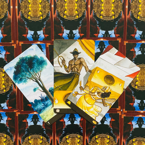 Tarot kortos fanuotos trys iliustruotos kortos (medis, karys ir šokėja) ant tamsios ornamentinės nugarėlės