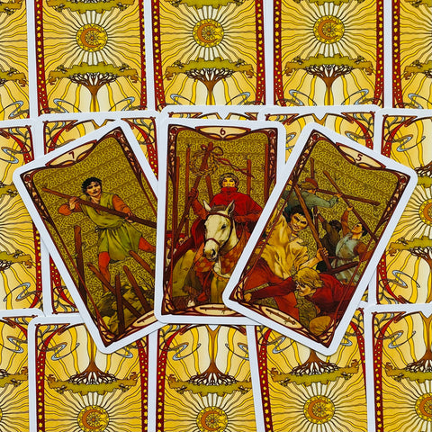 Tarot kortos Rider–Waite stiliaus su geltonomis nugarėlėmis, trijų kortų fanas ir detalūs iliustruoti motyvai