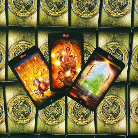 Tarot kortos Wands: trys atverstos kortos (4, 5, 6) su ugniniais oranžiniais motyvais ir žalvario nugarėlių raštu