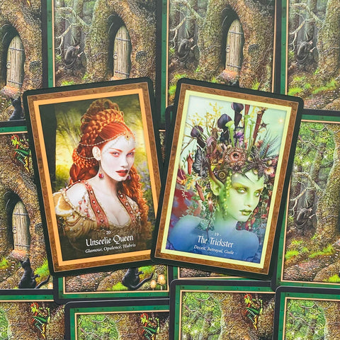orakulų kortos Unseelie Queen ir The Trickster priekiniai dizainai, ryškūs raudoni ir žali tonai, pasvirusios virš nugarinių kortų