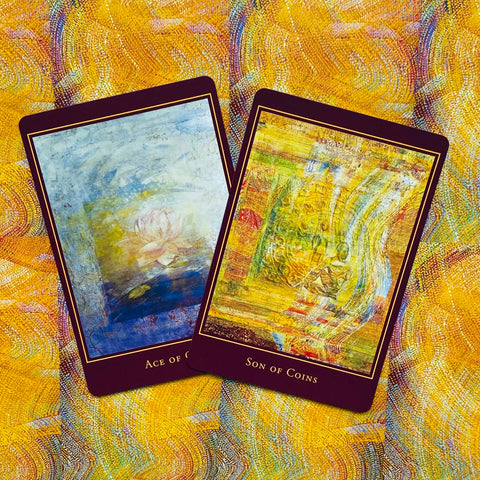 tarot kortos su dviem atvertais paveikslais (Ace of Coins, Son of Coins), geltoni ir mėlyni tonai, pasvirusios ant geltono raštuoto fono