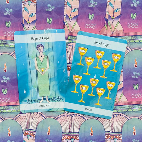 tarot kortos – mėlynos iliustracinės kortos (Page of Cups, Ten of Cups) parodytos ant violetinio ornamentuoto fono