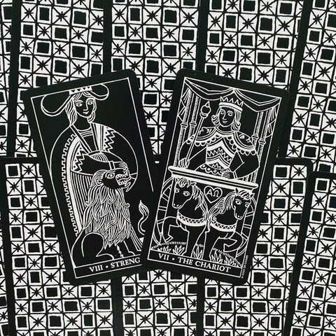 tarot kortos juodai baltos, atverstos „Strength“ ir „The Chariot“ kortos dėmesį traukiančiame juodai baltame geometriniame fone