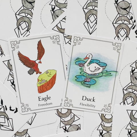 Gyvūnų oracle kortos su erelio (Freedom) ir antis (Flexibility) spalvotomis iliustracijomis, detalus kampinis rėmelis ir galinių kortų nugarėlių dizainas