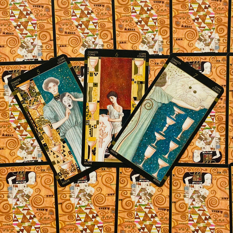 tarot kortos — trijų Taurių išklotinė, aukso ir mėlynos akcentai, dekoratyvus oranžinis nugarėlis