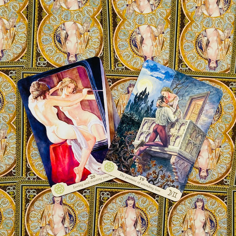 Tarot kortos – dvi atverstos kortos su romantinėmis iliustracijomis ant auksuoto raštuoto fono, fotografuotos iš viršaus