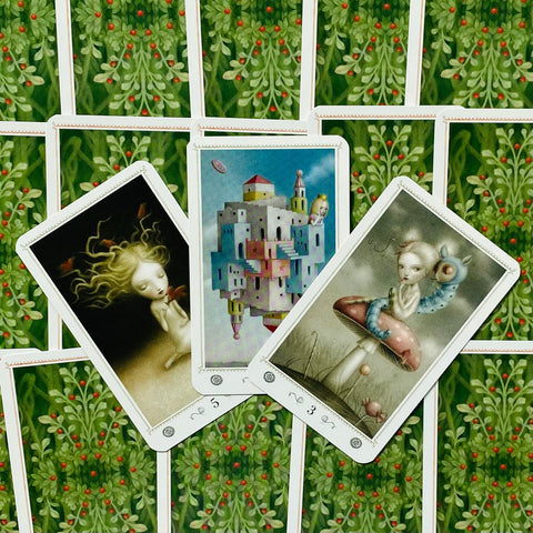 Tarot kortos trys atverstos kortos ant žalių lapų rašto nugarėlių, rodo skirtingus iliustruotus simbolius ir numerius