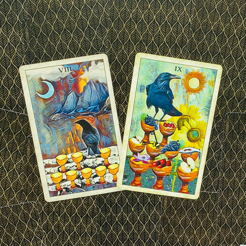 Tarot kortos du ilustruoti puodelių kortų variantai (VIII ir IX) su varno motyvu, pasvirusios ant rašto fono