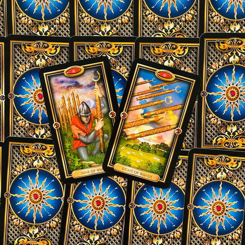tarot kortos komplektas, dvi kortos (Nine of Wands, Eight of Wands) išklotos skirtingomis pozomis ant mėlyno nugarėlių fono