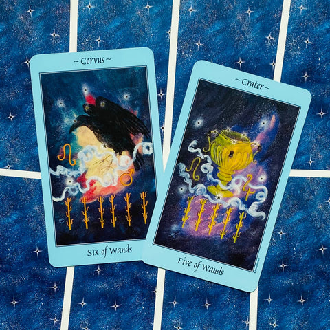tarot kortos mėlynomis kraštinėmis (Six of Wands ir Five of Wands) ant žvaigždėto fono, dvi kampu persidengiančios kortos