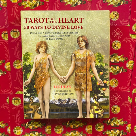 Prekės puslapyje Tarot of the Heart (Liz Dean) viršelis — dvi figūros susikibusios, auksiniai drabužiai ir raudonas ornamentuotas fonas, centrinis artimas kampas skiriasi nuo kitų variantų