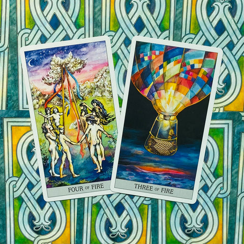 Tarot kortos, dvi ugnies kortos (Three of Fire, Four of Fire) ant žaliai mėlyno nugarėlių rašto, arti fotografuota kampu