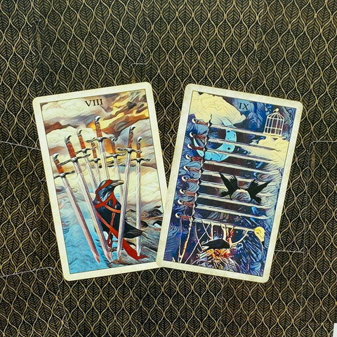 tarot kortos, dvi iliustruotos kalavijų kortos (VIII ir IX), ryškios mėlynos ir geltonos spalvos, padėtos kampu ant raštuoto tamsaus fono