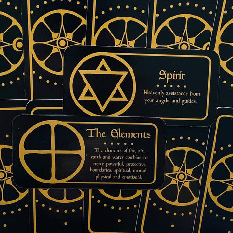 Orakulų kortos juodo fono su auksinėmis simbolikomis, matomos „Spirit“ ir „The Elements“ kortų priekinės pusės, artimas kampas