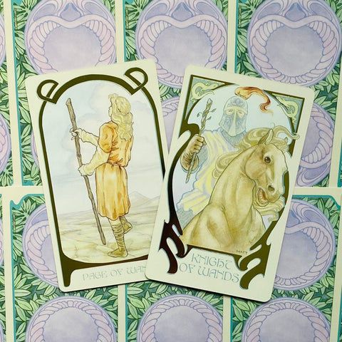 tarot kortos dvi Wandų kortos — Page ir Knight, pastelinės geltonos ir smėlio spalvos iliustracijos ant žalios raštuotos nugarėlės