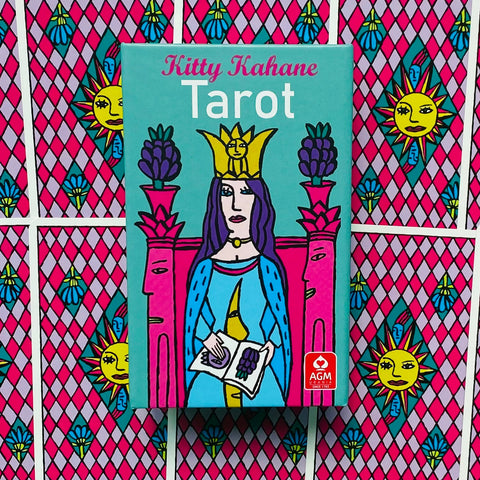 Tarot kortos Kitty Kahane mėlykai turkio dėžutėje su karalienės iliustracija centre ir matomu AGM logotipu