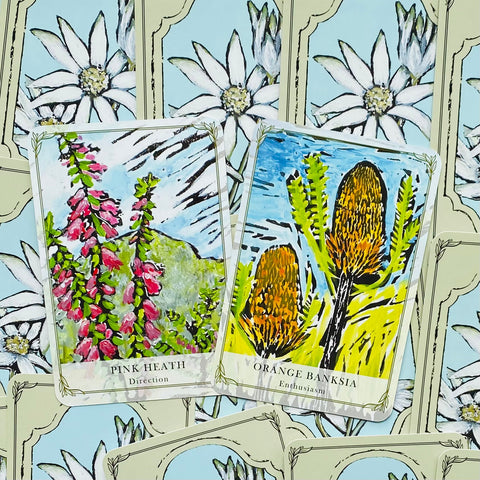 Orakulo kortos su ryškiomis botaninėmis iliustracijomis, dvi kortos (Pink Heath ir Orange Banksia) parodytos iš viršaus, sklandžiai persidengiančios