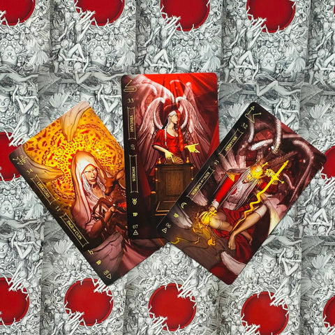 tarot kortos trijų kortų išdėstymas su raudonais ir auksiniais akcentais ant ornamentuoto raudno–pilko fono