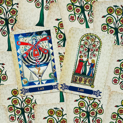 Tarot kortos pora: "Luck" ir "Love" kortos su balta gėlių raštu ant nugarėlės, detalus priekinis planas