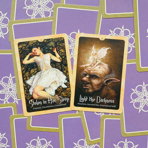tarot kortos dviejų kortų ištrauka: „Stolen in Her Sleep“ ir „Light the Darkness“ ant violetinio fono, fotografuota iš viršaus