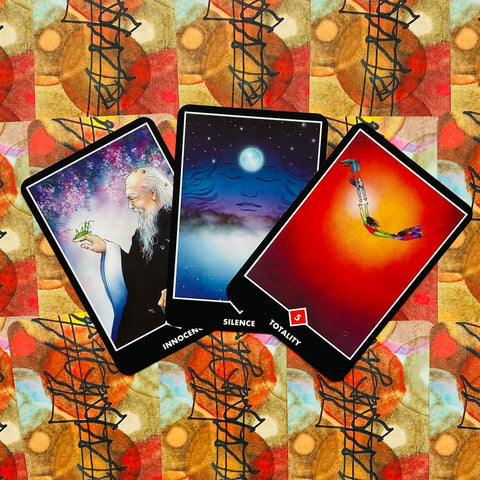 Tarot kortos Osho Zen, trys ryškios kortos ant abstraktaus raštuoto fono, išdėstytos iš viršaus, skirtingos temos