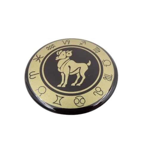 Sagė su Avino zodiako ženklu, juoda su auksiniu ornamentu, apvali metalinė segė, artimas priekinis planas