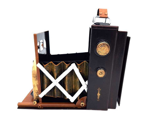 sulankstomas fotoaparatas juodos ir rudos spalvos su auksiniais akcentais, profilio matoma ištempta akordeono tipo gofruota membrana