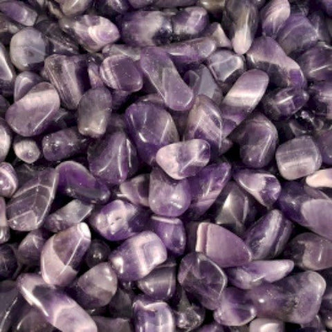 Ametisto tromluoti akmenys, artimas kadras pabrėžia blizgias violetines faktūras ir smulkias baltas juostas, skirtas papuošalams
