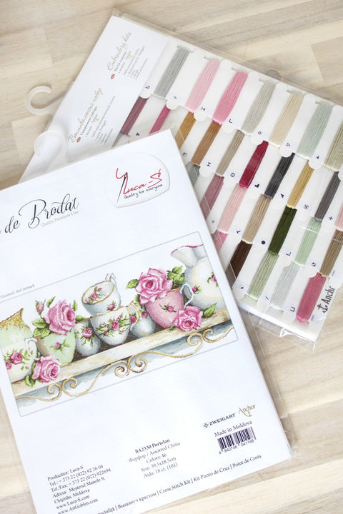 Siuvinėjimo rinkinys su rožių puodelių raštu, prieduose pastelinių Anchor siūlų kortelė ir modelio schema pagal instrukciją