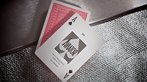 Pokerio kortos asas su juodu pikų dizainu ir raudona nugarėle, paguldytas ant tekstūruoto sidabro fono