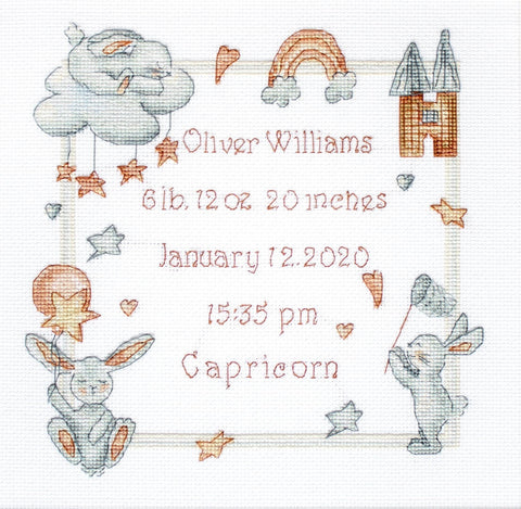 Gimimo plakatėlis su vardu Oliver Williams ir gimimo duomenimis, siuvinėtas šviesiai pilkais ir rudos tonų siūlais, kvadratinis 30×30 cm, rodoma priekinė pusė