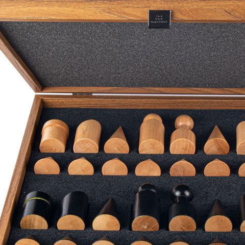 Medinės šachmatų figūros rudos ir juodos spalvos, išdėstytos atidarytame mediniame dėkle, artimas planas